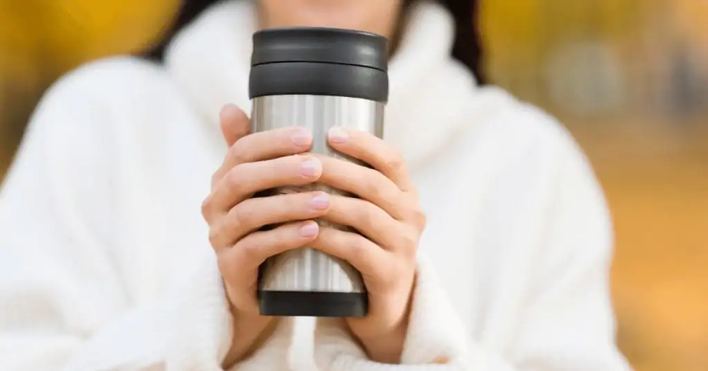 woman holding coffee thermos