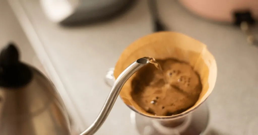 gooseneck kettle pouring water into a hario v60 brewer