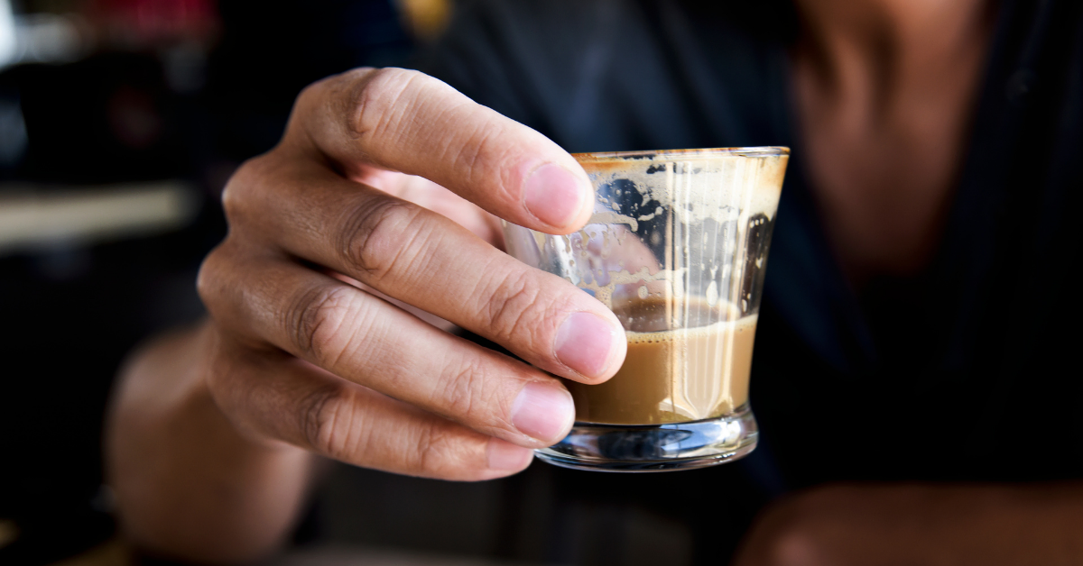 man holding macchiato coffee