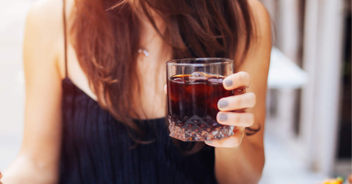 a woman pouring cold brew espresso in a glass