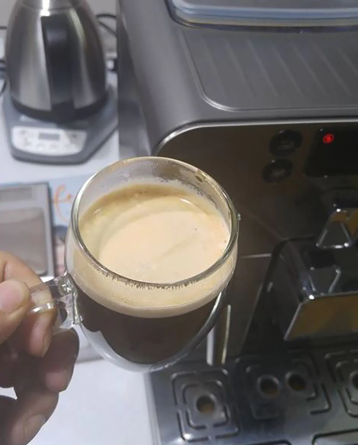 person holding espresso prepared on gaggia brera