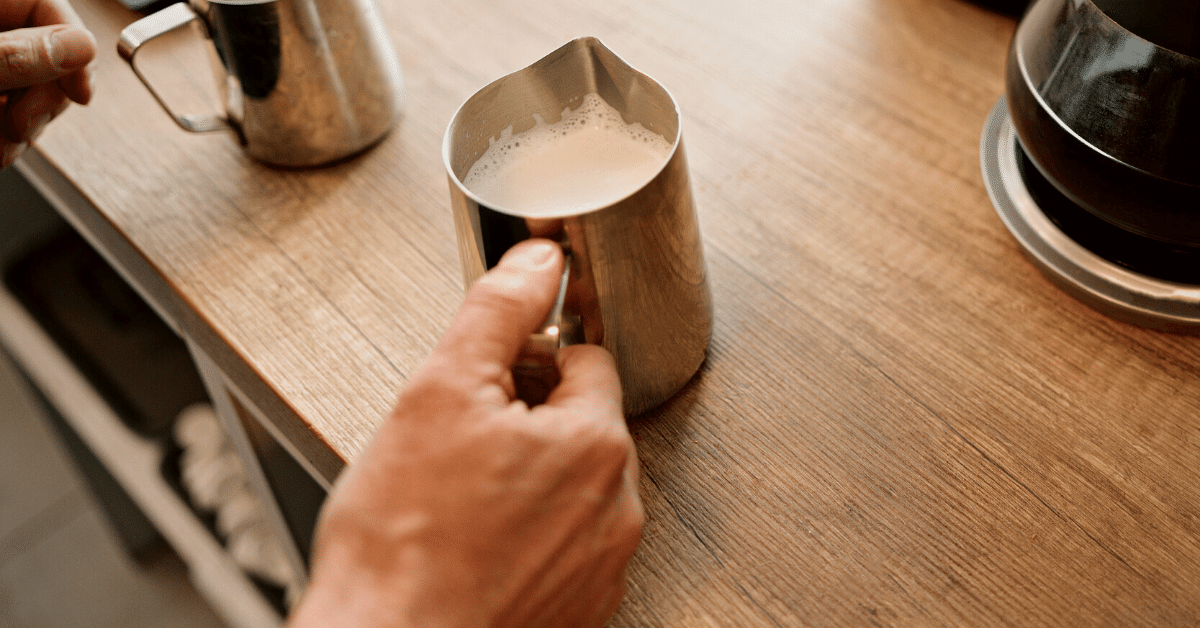 a person holding frothed milk