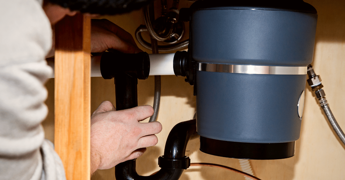 plumber fixing a garbage disposal