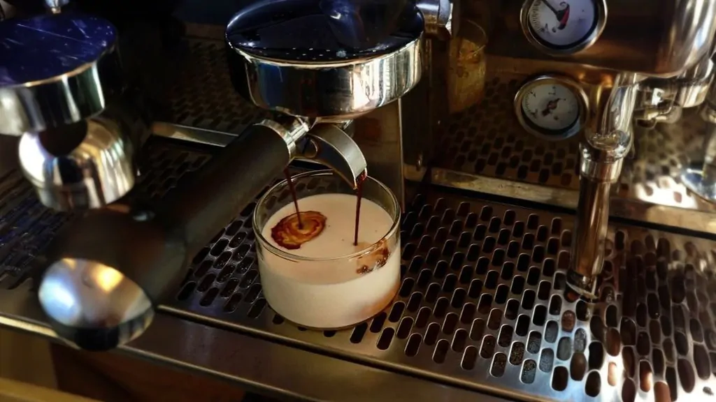 pouring coffee in a glass with milk