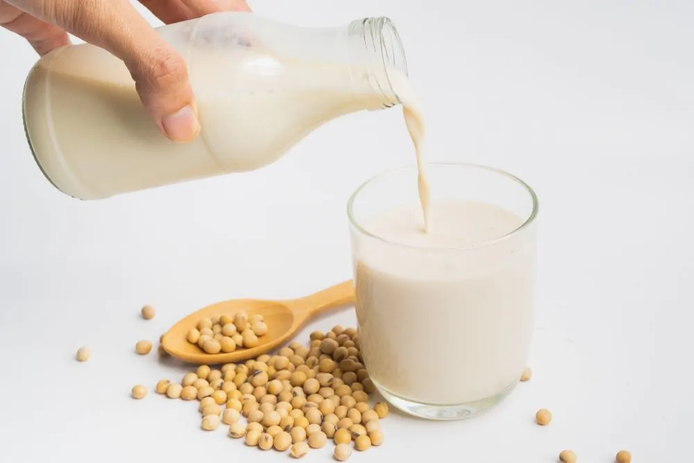 Bottled of soy milk poured into a glass